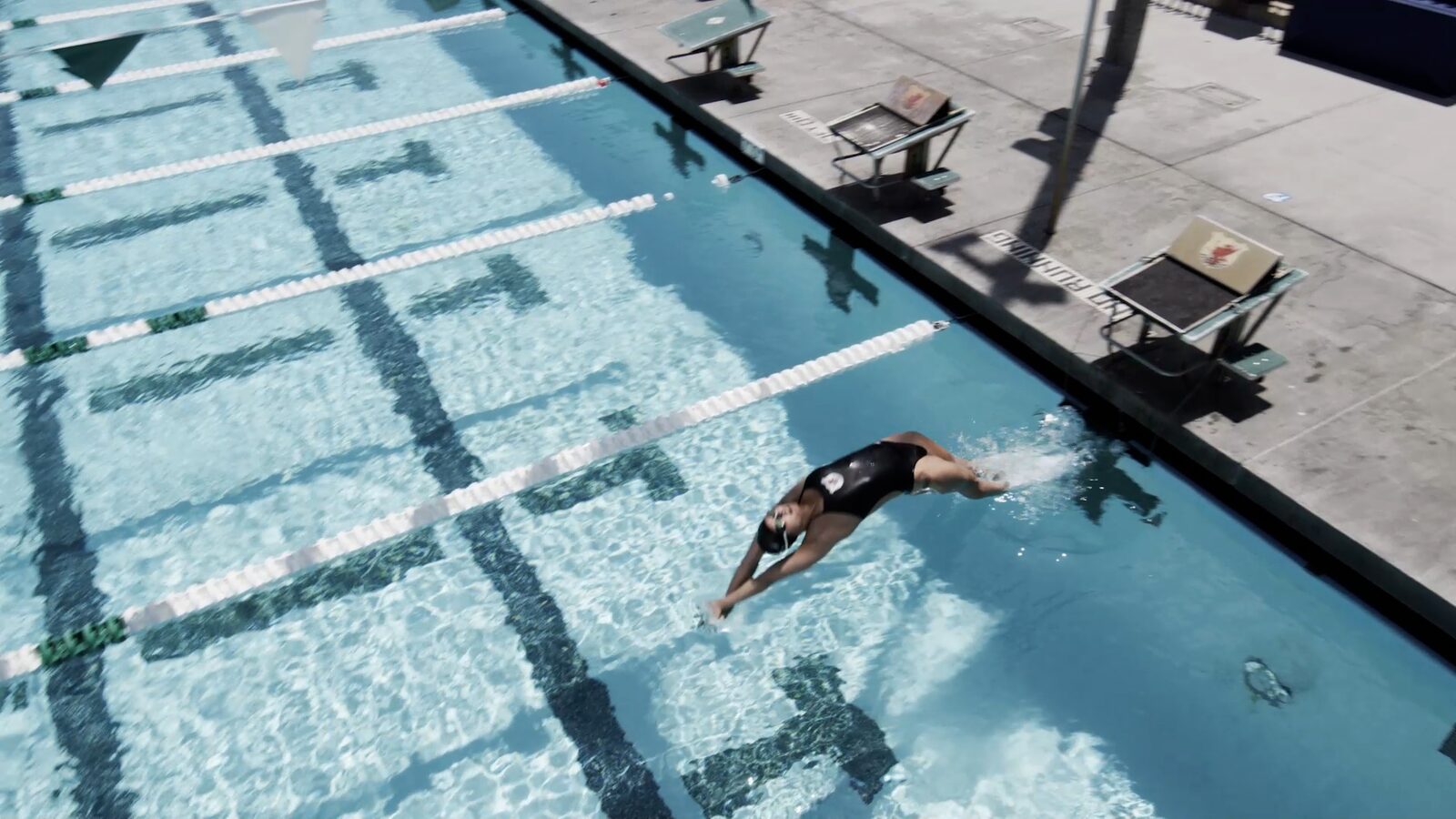 A swimmer diving overhead into a backstroke start entry at The Race Club